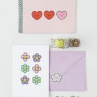 Drei Herzillustrationen, lila Umschlag mit Wolkensticker, Karte mit Blümchen, bunte Stickerrollen.