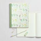 Notizbuch mit Blumenmuster, Text: "Notebook 160 pages bamboo paper". Daneben Stift, Radiergummi, Büroklammern.