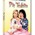 "Die Teufelin" in roter Schrift. Meryl Streep mit Hund, Roseanne Barr überrascht. Bunte Kleidung auf gelbem Hintergrund.