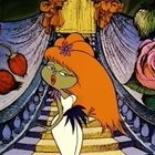 Eine Figur mit grüner Haut, rotem Haar und weißem Kleid steht vor einer prunkvollen Treppe, umgeben von Blumen.