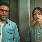 Zwei Personen schauen aufmerksam nach vorn. Der Mann hat einen Bart und Brille, die Frau hat lange Haare. Im Hintergrund sind Bilder an der Wand.