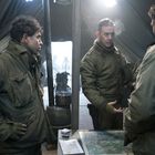 Personen in Militäruniformen in einem Zelt, eine Karte liegt auf dem Tisch. Sie scheinen eine Besprechung zu führen.