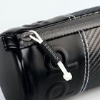 Der Text "s.madepp" ist auf einem kleinen schwarzen Etikett an einem schwarzen Lederetui mit weißen Nähten.