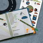 Notizbuch mit handgeschriebenen Lieblingssachen, daneben Rennwagen-Sticker auf blauem Teppich.