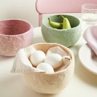 Es gibt keinen Text zu erwähnen. Drei farbige Filzschalen, eine rosa, grün und beige, gefüllt mit Birnen und Eiern.