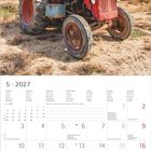 5 · 2027. Kalender mit rotem Traktor auf sandigem Untergrund, blauer Himmel mit weißen Wolken.