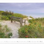 Mai 2027, Kalenderansicht. Holzbänke in den Dünen am Strand mit Blick aufs Meer, umgeben von Gras und Sträuchern.