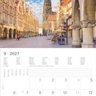 Kalender, September 2027, mit bunten Wimpeln über einer belebten europäischen Straße mit alten Gebäuden und Kirchturm.