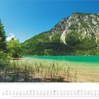 Alpine Berglandschaft am Heiterwanger See, Tirol, Österreich. Klare, türkisfarbene See mit Bergen im Hintergrund, umgeben von Wald. Darunter ein Kalender für den Monat Mai.