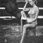 Kalenderblatt Mai, Frau im Freien, nackt, liest, Pferd daneben, rustikale Umgebung.