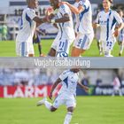 Text: „Vorjahresabbildung“. 

Szene: Fußballspieler in weiß-blauen Trikots jubeln und einer dribbelt mit dem Ball.