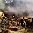 Illustration einer historischen Schlacht mit Kanonen, Rauch und Soldaten in Aktion auf einem Feld.