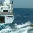 Text "P843" auf einem grauen Marineschiff, daneben im Wasser ein Schnellboot mit Soldaten.