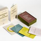 Karten und Box mit Texten zu Meditation und Achtsamkeit. Buch und farbige Karten liegen ausgebreitet.