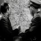 Zwei Personen in Uniform zeigen auf eine große Karte.