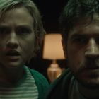 Ich kann keine Texte erkennen. Zwei Personen schauen überrascht, im Hintergrund eine Lampe.