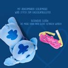 Blauer Hintergrund mit einem blauen Plüschfigur, daneben eine rosa Schlafmaske. Texte oben: "Mit abnehmbarer Schlafmaske", "Besonders schön: Die Maske kann auch selbst getragen werden".