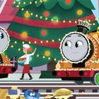 „We look like gingerbread engines!“ Zwei Lokomotiven mit Lebkuchen-Dekoration stehen vor einem Weihnachtsbaum. Ein Koch trägt eine Schüssel.