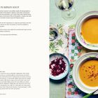 Rezept für afghanische Kürbissuppe, Zutaten: Kürbis, Milch, Ingwer. Neben der Suppe Wein und Chilipulver auf floralem Tuch.
