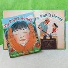 „My Papi's Hands“: Kinderbuch mit einem Mädchen, umarmt von Händen; Illustration von Mann und Mädchen.