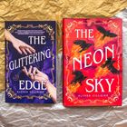 Links steht "The Glittering Edge" von Alyssa Villaire auf einem lila Hintergrund mit Händen. Rechts "The Neon Sky" auf Rot.