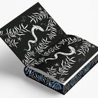 Eine Illustration mit weißen Schlangen und Blättern auf schwarzem Hintergrund. Auf dem Buchrücken sind blaue Details.