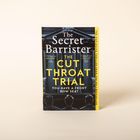 Buchtitel: "The Cut Throat Trial" von "The Secret Barrister." Drei Personen von hinten, gerichtliche Atmosphäre.