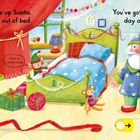 Zwei Texte: „Wake up Santa, jump out of bed.“ und „You’ve got a special day ahead!“ In heller Illustration: Frau, Geschenk, Zug.