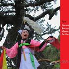 Text: "Part 1 Encountering Korean Shamanistic Deities. A shamanic dance performed before a village guardian tree." Eine Tänzerin in traditioneller Kleidung vor einem großen Baum.