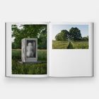 "Edition 8 WOOD" steht oben. Links eine Statue in einer Vitrine im Grünen, rechts Bäume auf einer Wiese.