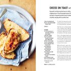 "CHEESE ON TOAST with kasoundi." Auf einem Teller liegen Brotscheiben mit geschmolzenem Käse und Kasoundi neben einem Glas.