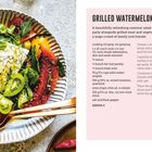 **GRILLED WATERMELON & FETA SALAD**

Ein leckerer Sommersalat mit gegrilltem Wassermelonenstück, Feta, Tomaten und Kräutern auf einem Teller.