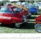 "FEUERWEHR" auf einem roten, kleinen Feuerwehrfahrzeug. Nummernschild: DGF 0701. Holzbalken tragend.