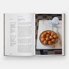 Links steht ein Rezept für Arancini, rechts ein Tisch mit einer Platte voller goldbrauner Reisbällchen, daneben Gläser.