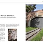 „THE POPE'S RAILWAY: The shortest international railway in the world.“ 
Text beschreibt die vatikanische Zugverbindung. Rechts Gebäude mit Tor und Schienen.
