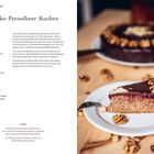 Links steht das Rezept für einen Schoko-Preiselbeer-Kuchen. Rechts ein Stück Kuchen mit Schokolade und Nüssen auf einem Teller.