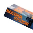 Der Text lautet "NICHTS IST VERGESSEN". Zu sehen ist der Buchrücken eines Buches mit blauer und orangefarbener Gestaltung.