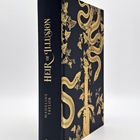 "Heir of Illusion" von Madeline Taylor. Goldenes Schlangen- und Pflanzenmotiv auf dunklem Hintergrund. dtv-Logo unten.