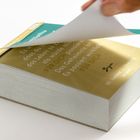 Ein Stapel Zettel mit dem Text: „Es wird passieren, FÜR DICH. 01. Januar – Freitag. NEUJAHR“. Eine Hand blättert um.