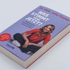 Text „Was stimmt denn jetzt? Orientierung im Gesundheitschaos online wie offline“. Frau in rotem Shirt sitzt fröhlich.