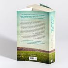 Rückseite eines Buches mit dem Titel "Das Geheimnis der Frauen" von Sonja Roos. Wiese und Wald im Hintergrund.