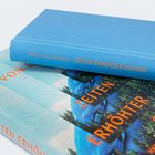 "Julia von Lucadou ZEITEN ERHÖHTER GEFAHR" in Orange auf einem blauen Buch. Cover zeigt blaue Landschaft.