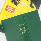 Der Buchrücken eines grünen Buches zeigt "Alex Capus QUER FELD EIN" in goldener Schrift. Darunter ein gelbes Cover.