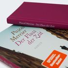 "Pascal Mercier Der Fluss der Zeit" auf Buchrücken und Cover eines dunkelroten Buches; HANSER, SPIEGEL Bestseller-Autor.