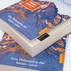 Text: „Eine Philosophie der besten Jahre“, „HANSER“. Zwei gestapelte Bücher mit abstraktem, farbenfrohem Cover.