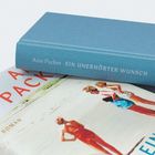 Der Buchrücken zeigt "Ann Packer EIN UNERHÖRTER WUNSCH". Ein Cover darunter zeigt Menschen am Strand.