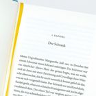 Text auf einer Buchseite: "1. Kapitel Der Schrank". Unter dem Titel beginnt der Fließtext. Ein gelbes Leseband ist zu sehen.