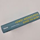 Rücken eines Buchs: „ZWEI MENSCHEN SIND IN MIR“ von Andrea Stoll, Verlag Piper, dunkelgrauer Hintergrund.