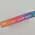 "A. T. QURESHI, The BABY DRAGON BAKERY, PIPER" ist auf dem Buchrücken zu lesen; bunte Farbverläufe und ein Drachenlogo.