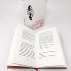 Text: "Robert Seethaler Die Straße." Zwei Bücher, eins stehend mit Hülle, eins offenliegend mit sichtbaren Seiten.